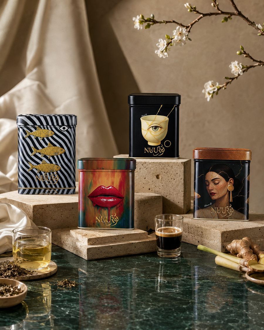 The four First Light artwork tins on travertine stone beneath a cherry-blossom branch