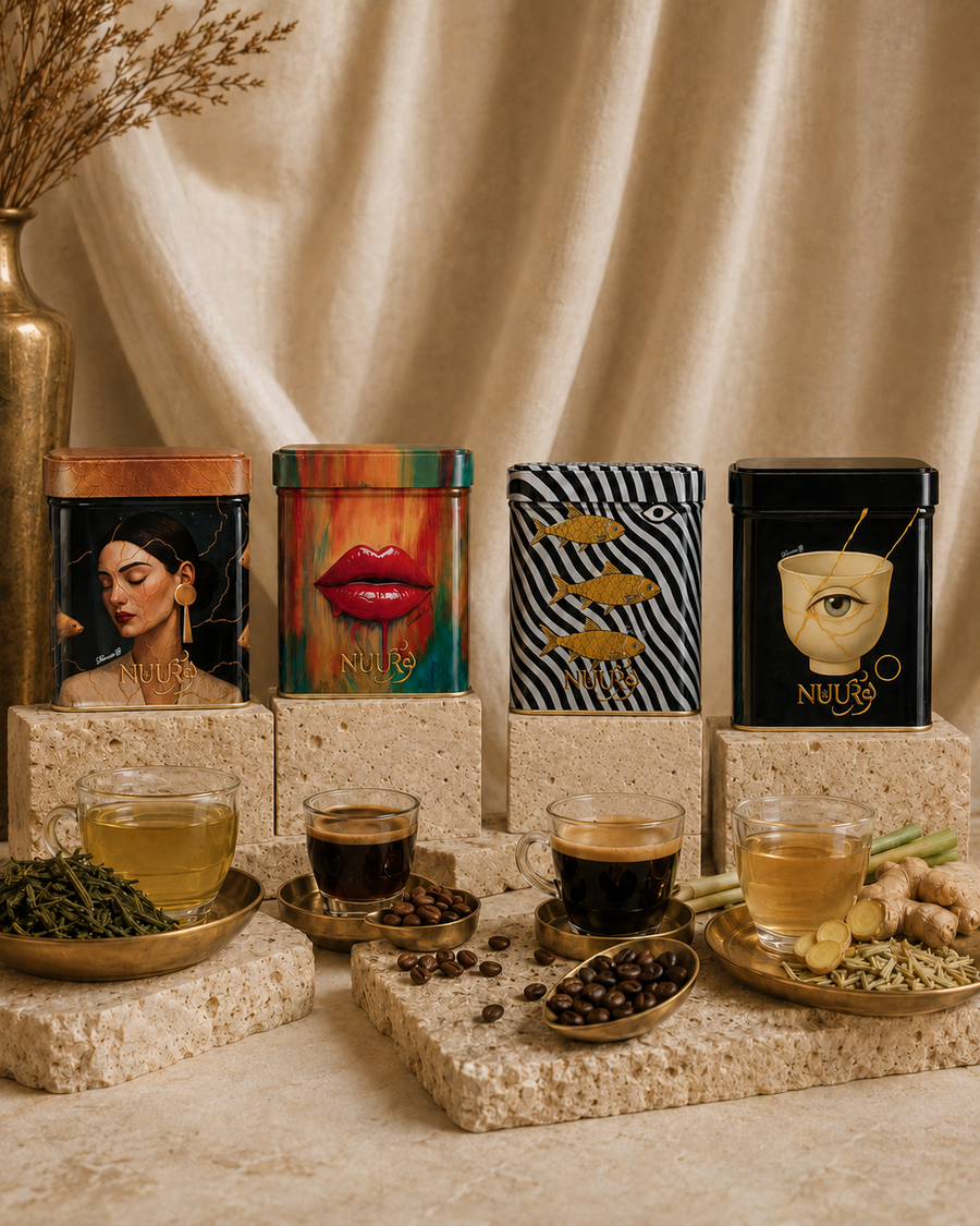 The four First Light artwork tins on travertine stone with silk drape, espresso, sencha and ginger