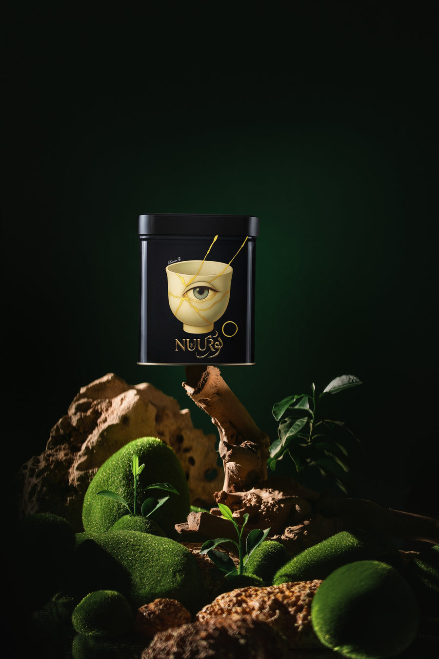 I Glow artwork tin resting on moss and tea leaves